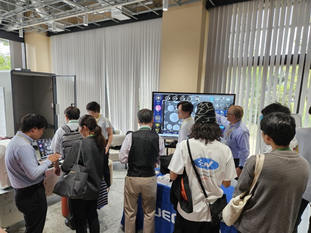 展示ブースを訪れる来場者の皆さん（卓上型電子顕微鏡の体験コーナー）