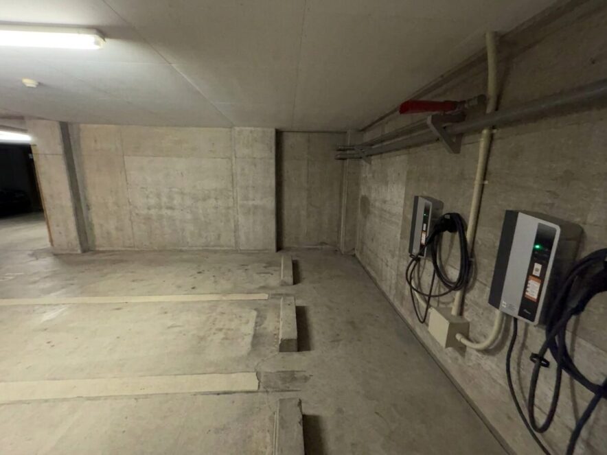 分譲マンションの駐車場に設置されたEV充電器のイメージ