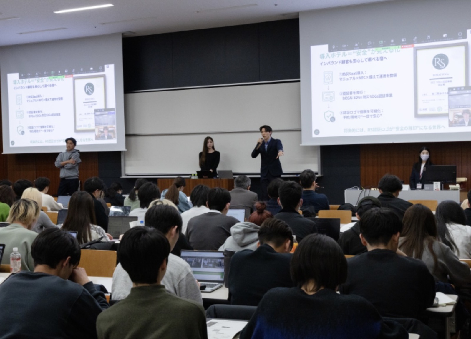大学の講義室でスライドを使って防災の講演を行うRevive & Surviveのメンバー