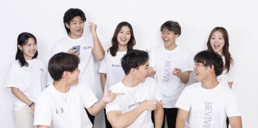 Revive & Surviveのメンバーが白いTシャツで笑顔で集まっている集合写真